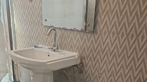 Et badeværelse med håndvask, toilet og spejl.