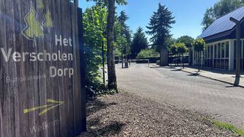 Un panneau en bois indiquant « Het Verscholen Dorf » et « Bungalowpark », signalant la présence d’un parc.