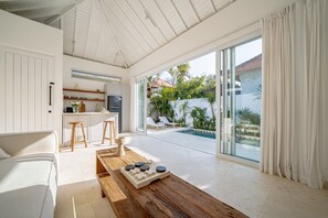 Interior moderno com cozinha, sala de jantar e vista para a piscina.