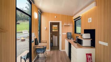 A compact kitchen with a dining area, a fire blanket, and a view of the outdoors.