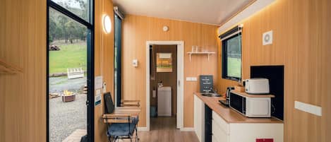 A compact kitchen with a dining area, a fire blanket, and a view of the outdoors.