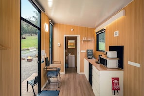 A compact kitchen with a dining area, a fire blanket, and a view of the outdoors.