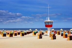 Ein Strand mit Liegestühlen und einem Rettungsturm.