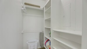 A white laundry room with shelves, a basket, and a towel rack. - On 174 Acres! Ranch House in Colorado County (Weimar)