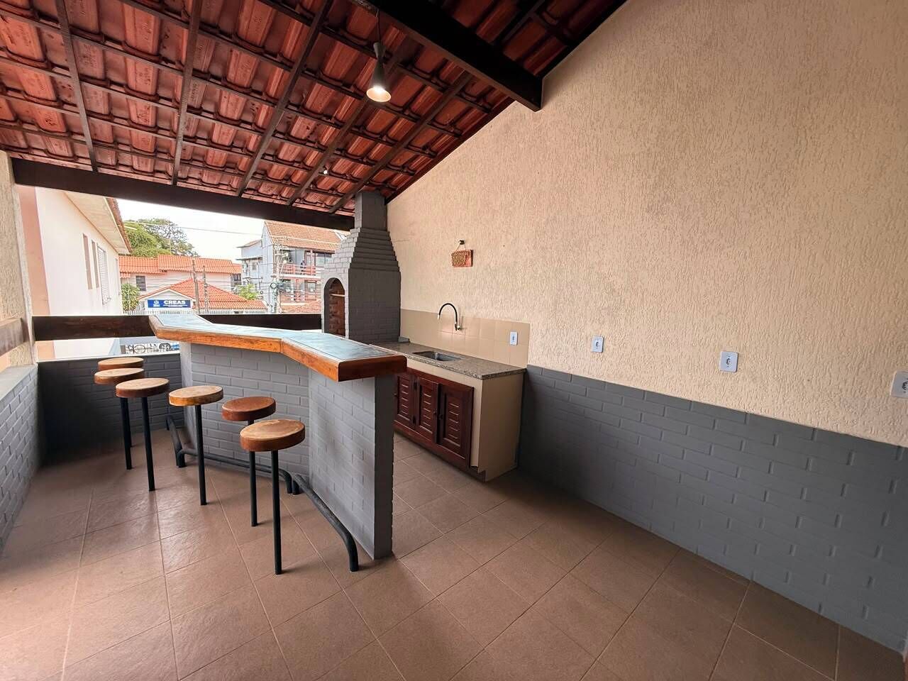 Une cuisine avec un coin bar, des tabourets et une vue sur la rue.