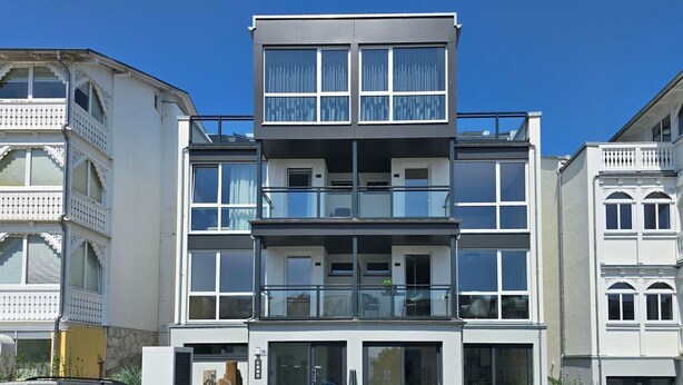 En flereetagers boligbygning med altaner, store vinduer og moderne arkitektur.