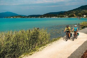 Un camí al costat d'un llac amb dos ciclistes.