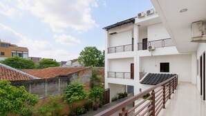 Un edificio a più piani con balconi, tetto in tegole e piante in vaso.