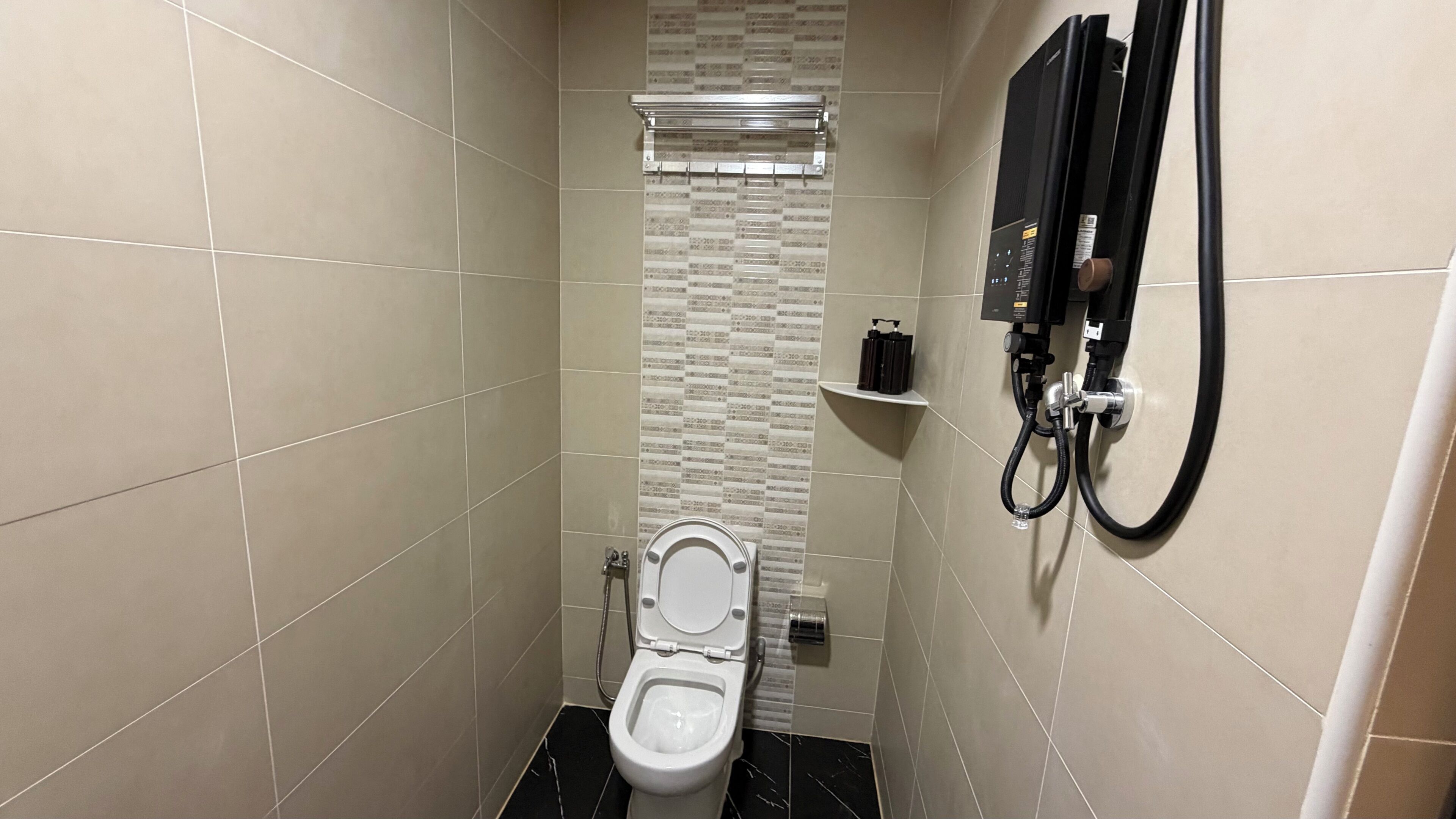 A small, modern bathroom with a toilet, a shower, and a towel rack.