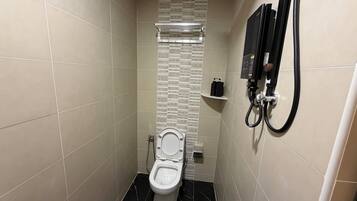 A small, modern bathroom with a toilet, a shower, and a towel rack.