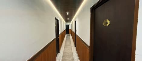 A hotel hallway with wooden paneling, a carpeted floor, and a door marked with the number 109.