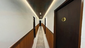 A hotel hallway with wooden paneling, a carpeted floor, and a door marked with the number 109.