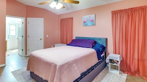 A bedroom with a bed, a nightstand, a ceiling fan, a door, and a window. - Pool, Hot Tub & Kids' Play Area! Davenport Home (Davenport)