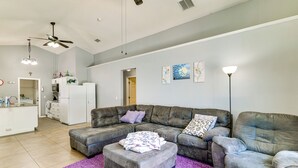 A living room with a grey sectional sofa, a matching ottoman, and a purple rug. - Pool, Hot Tub & Kids' Play Area! Davenport Home (Davenport)