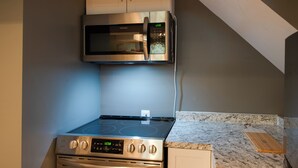 Una cocina equipada con microondas, horno y estufa.