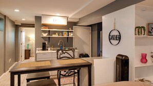 Una cocina compacta con comedor, una cafetera y un letrero en la pared.