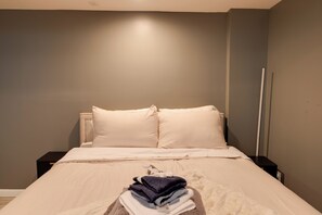 A neatly made bed with pillows and a folded towel on the side. - Remote Work Haven! Studio 8 Mi to Lincoln Memorial (Washington)