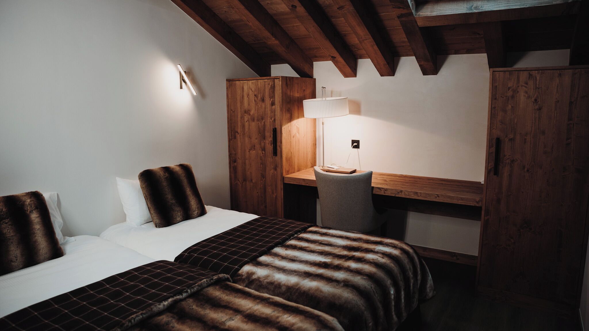 A bedroom with a bed, a desk, and a chair.