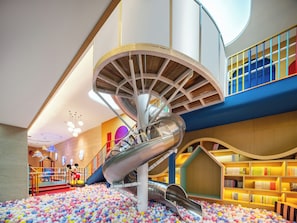 Un espace de jeux pour enfants avec un toboggan en spirale et une piscine à balles.
