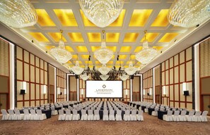 A conference room with multiple tables, chairs, and chandeliers.