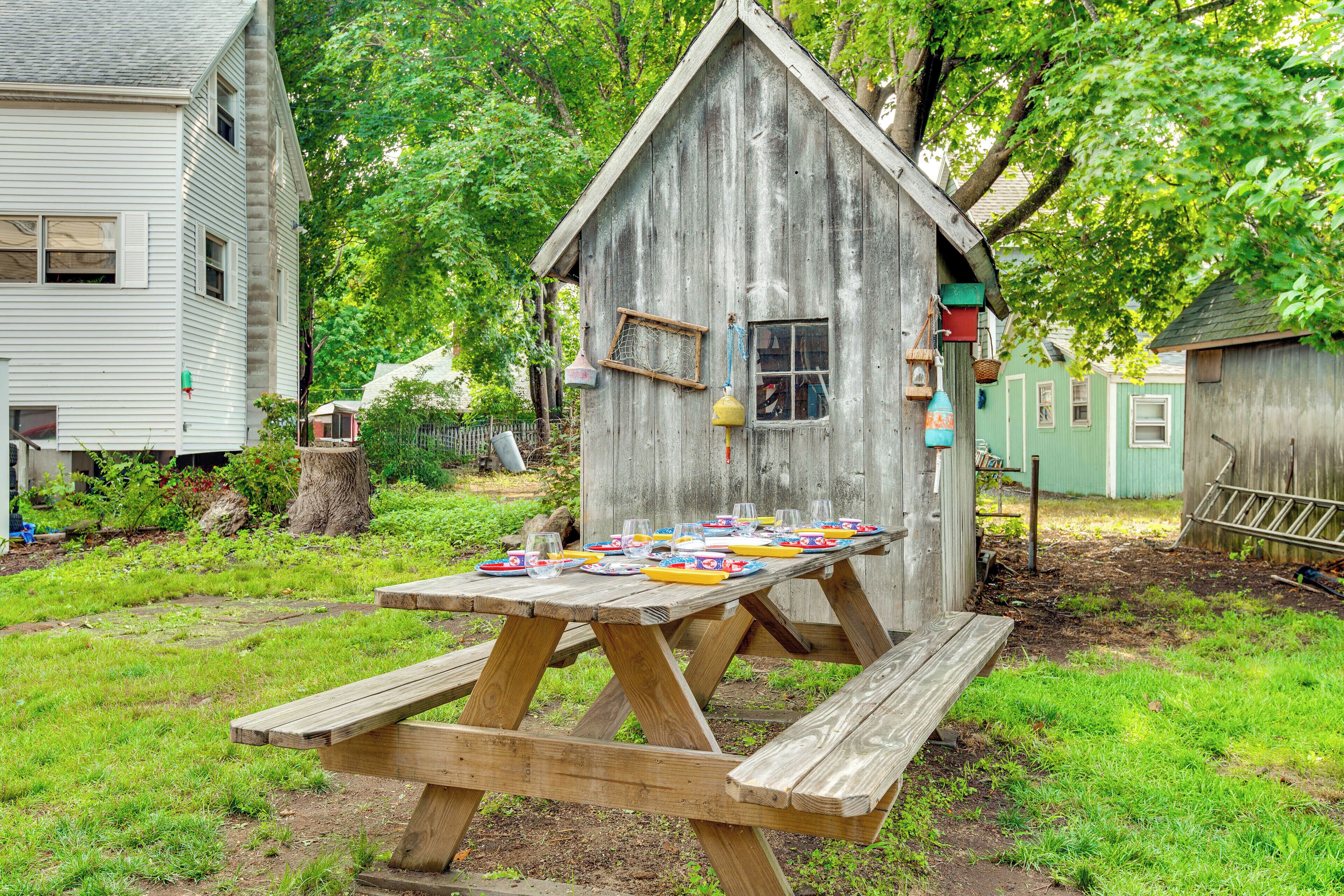 Una estructura de madera con una mesa de picnic frente a ella.