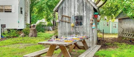 Una estructura de madera con una mesa de picnic frente a ella.