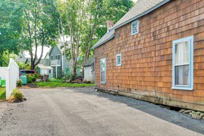 A residential property with a gravel driveway, wooden siding, and a small front yard with a tree. - Tiny Antique Cottage - 2 Minutes From Short Sands! (York)