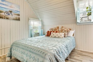 A bedroom with a bed, a window with shutters, and a painting on the wall. - Tiny Antique Cottage - 2 Minutes From Short Sands! (York)
