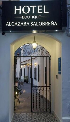A hotel entrance with a wrought iron gate, a sign above reading 'HOTEL BOUTIQUE ALCAZABA SALOBREÑA,' and a pathway leading to the interior. - Deluxe Apartment with Garden View / Bright, spacious, and comfortable (Salobreña)