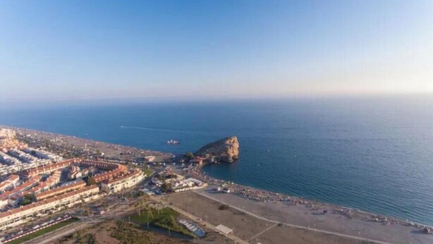 An aerial view of a coastal town with a prominent rocky outcrop, a beach, and a densely built urban area with terraced buildings. - Luxury Studio with a Terrace and Views of the Alcazaba (Salobreña)