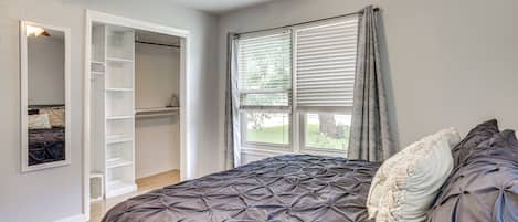 Un dormitorio con cama, armario y ventana con persianas.