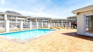 Ein Hotel mit Schwimmbad, mehreren Balkonen und einem überdachten Außenbereich.
