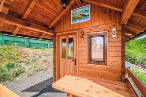A wooden cabin with a number '2' sign, a window, and a bench outside.