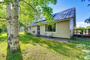 A single-story house with a front porch, a small garden, and a metal roof.