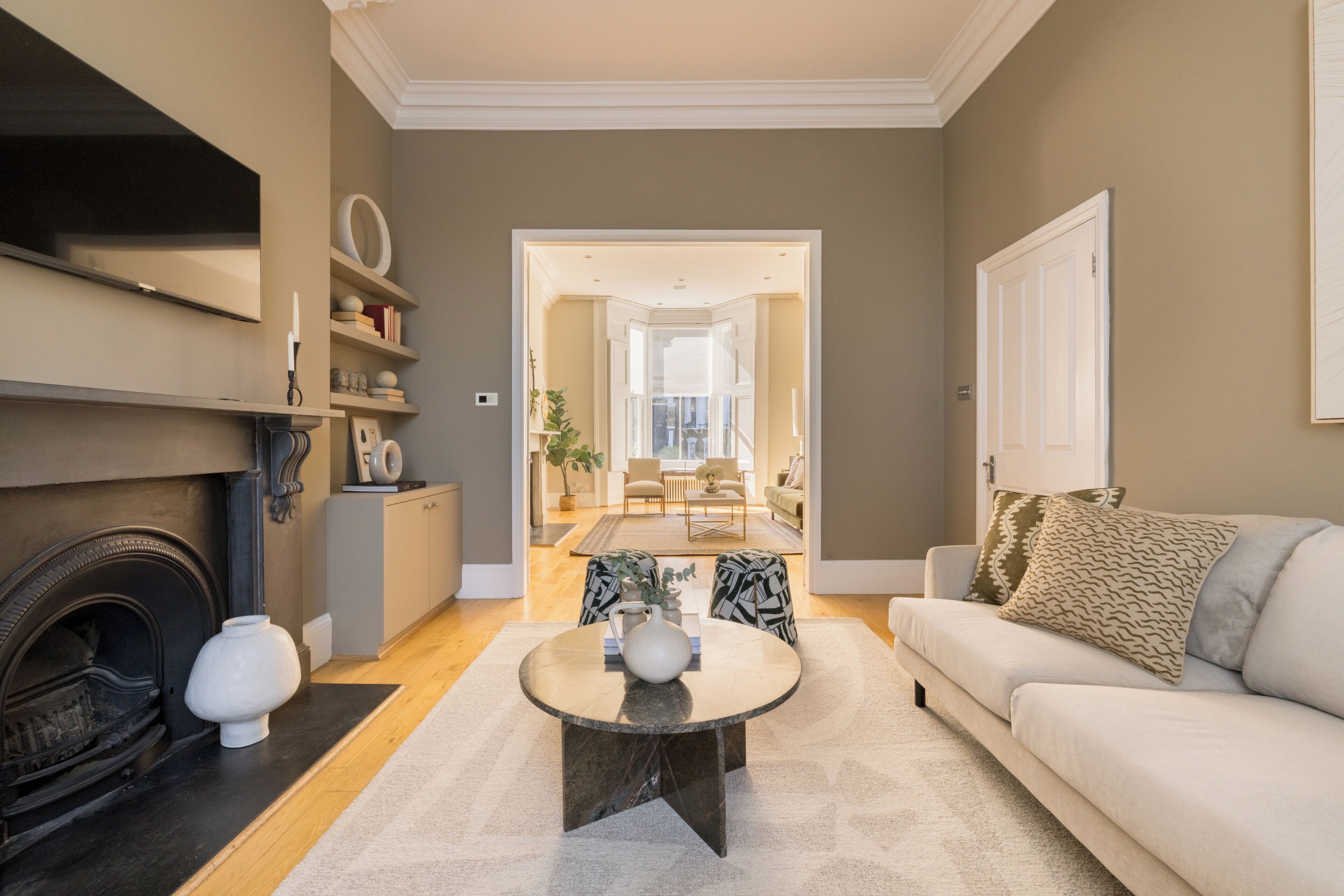 A living room with a fireplace, a sofa, a coffee table, and a bookshelf.