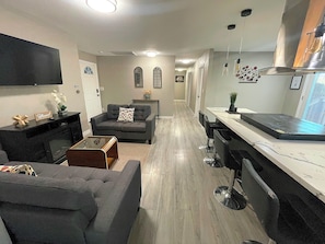 Una cocina moderna con comedor, sofá y televisor.