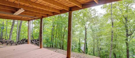 Una terraza de madera con vista a un bosque.