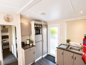 A compact kitchen with a microwave, refrigerator, and a sink. - Aldous Rest - Cosy Park Home in quiet Norfolk Countryside (Fritton)