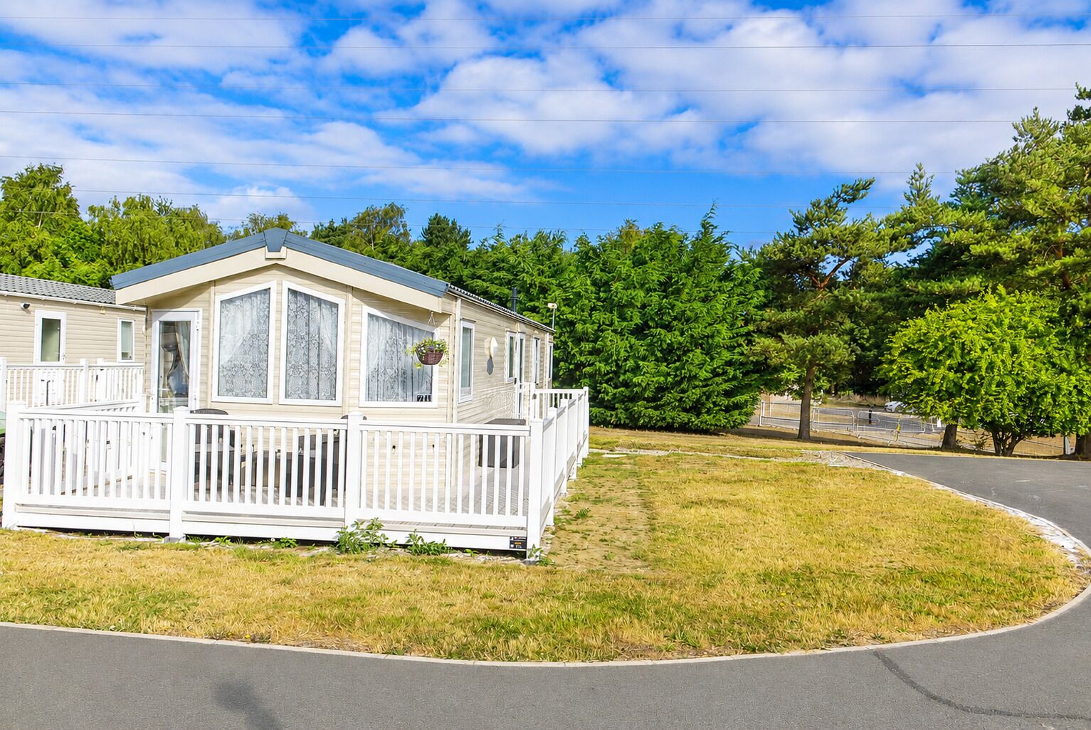 Une maison mobile dotée d’une véranda et d’une cour clôturée.