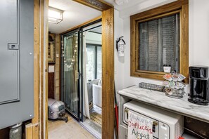 Eine Küche mit Marmorarbeitsplatte, einer Kaffeemaschine und einem an der Wand befestigten Feuerlöscher.