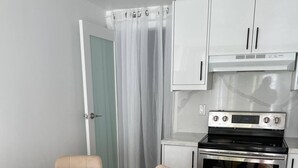 Uma cozinha moderna com forno embutido e mesa de jantar com tampo de mármore e cadeiras.