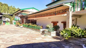 Un patio con suelo de piedra, una zona de estar cubierta y plantas en macetas.