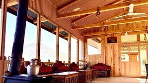 Un interior rústico de madera con un horno grande, muebles de madera y ventanas amplias.