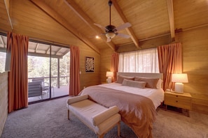 Ein gemütlicher Holzraum mit einem Bett, einer Bank und einem Deckenventilator.