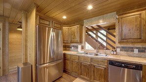 A modern kitchen with stainless steel appliances, wooden cabinets, and a stone backsplash. - Sunset Views + Scenic Trails: Spacious Pine Escape (Pine)