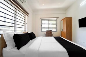 Ein Schlafzimmer mit Bett, Schreibtisch, Stuhl und Kleiderschrank.