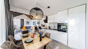 A modern kitchen with white cabinets, a dining table set with plates, glasses, and cutlery. - Holiday home Dubravka by Villas Guide (Blato)