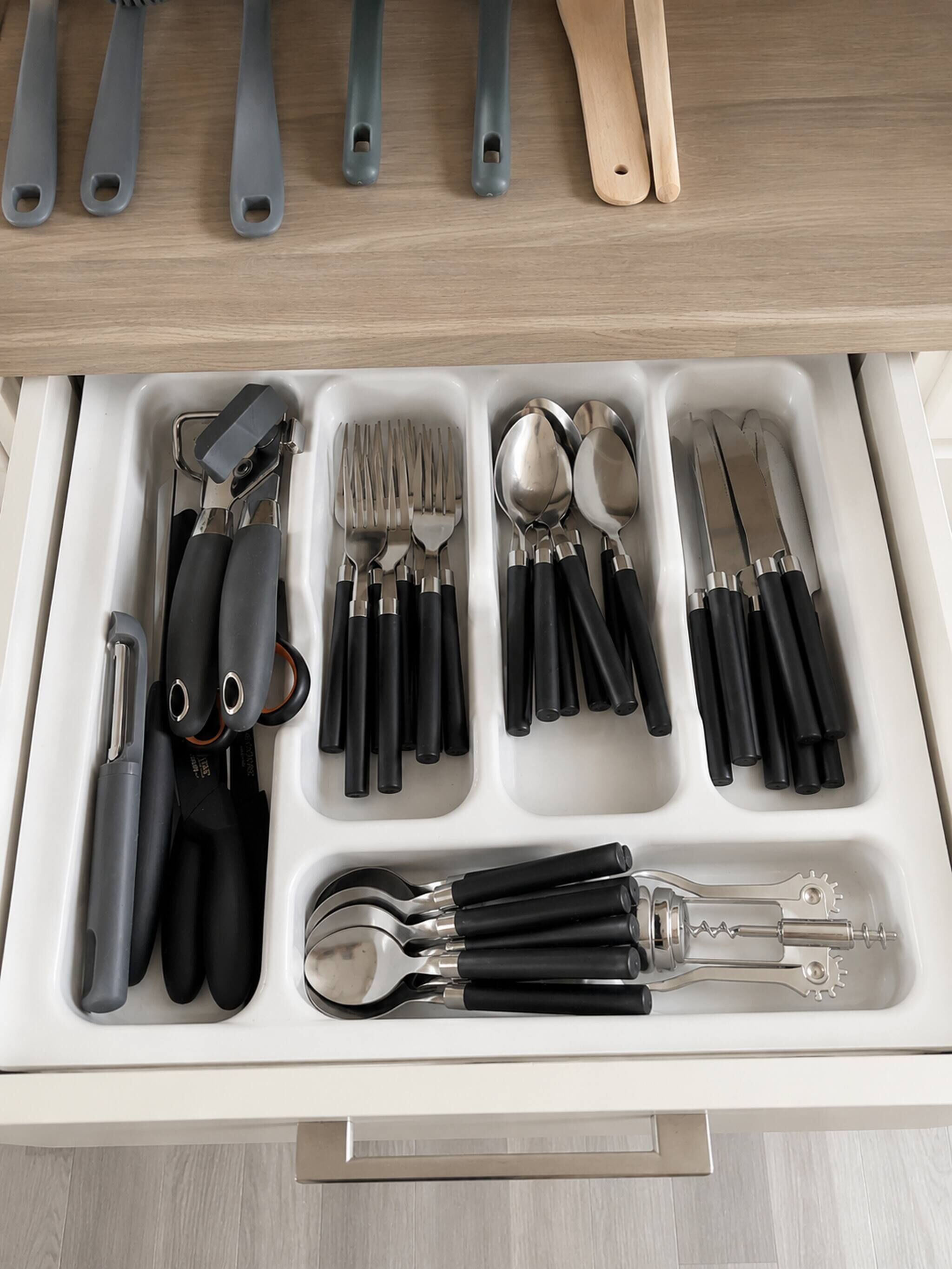 A drawer with various kitchen utensils neatly organized.
