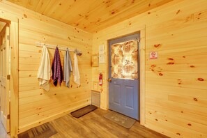 A wooden interior with a blue door, towels hanging on a rack, and a fire extinguisher.