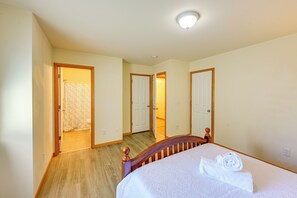 A hotel room with a wooden bed, a bathroom with a shower curtain, and a hallway with doors leading to other rooms. - Great for Families! Spacious Retreat in Lynnwood (Lynnwood)